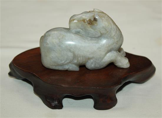 A Chinese mottled pale grey jade figure of a recumbent horse, probably Ming dynasty, 7.2cm, wood stand